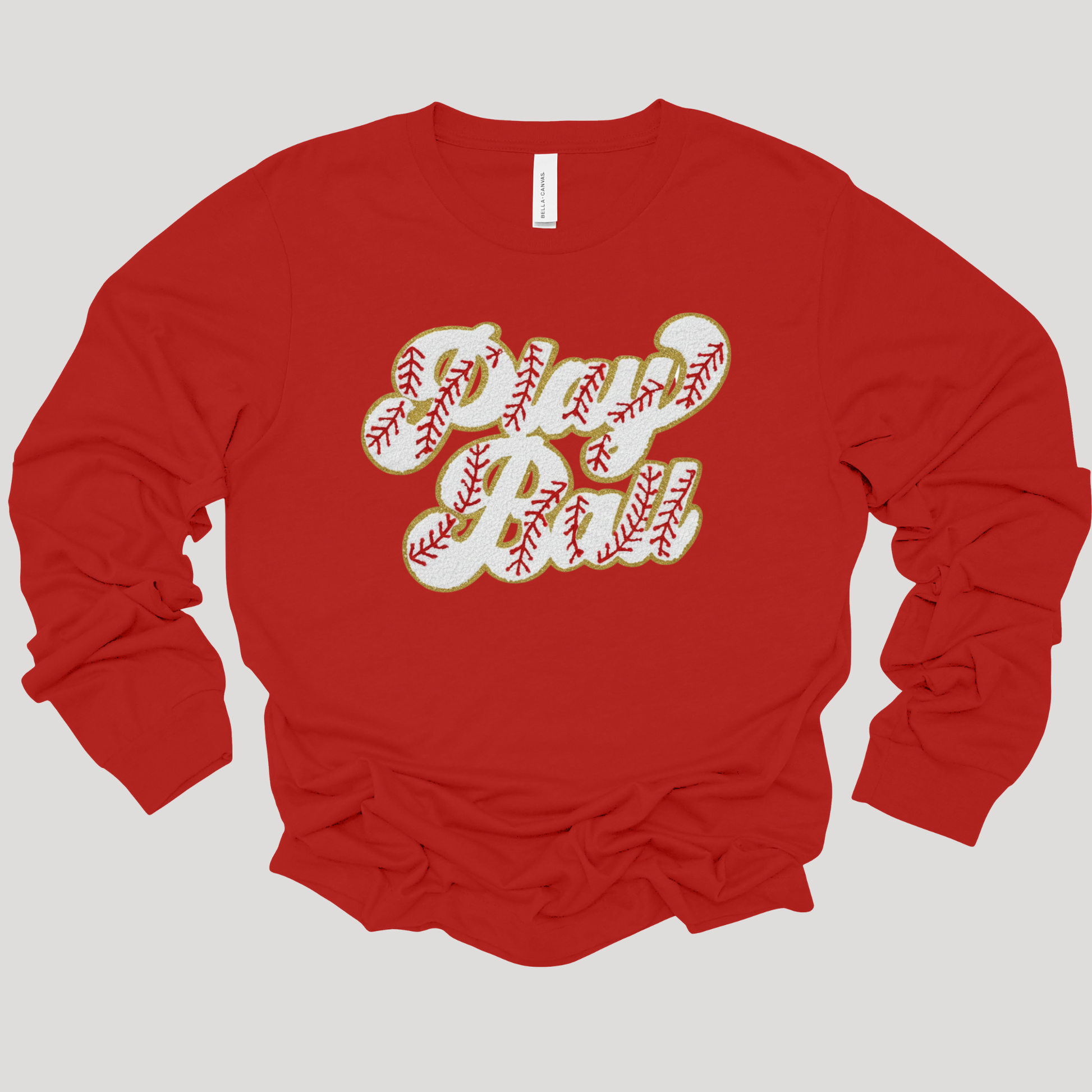 Red long-sleeve shirt with 'Dad' printed in baseball-themed text on a light gray background