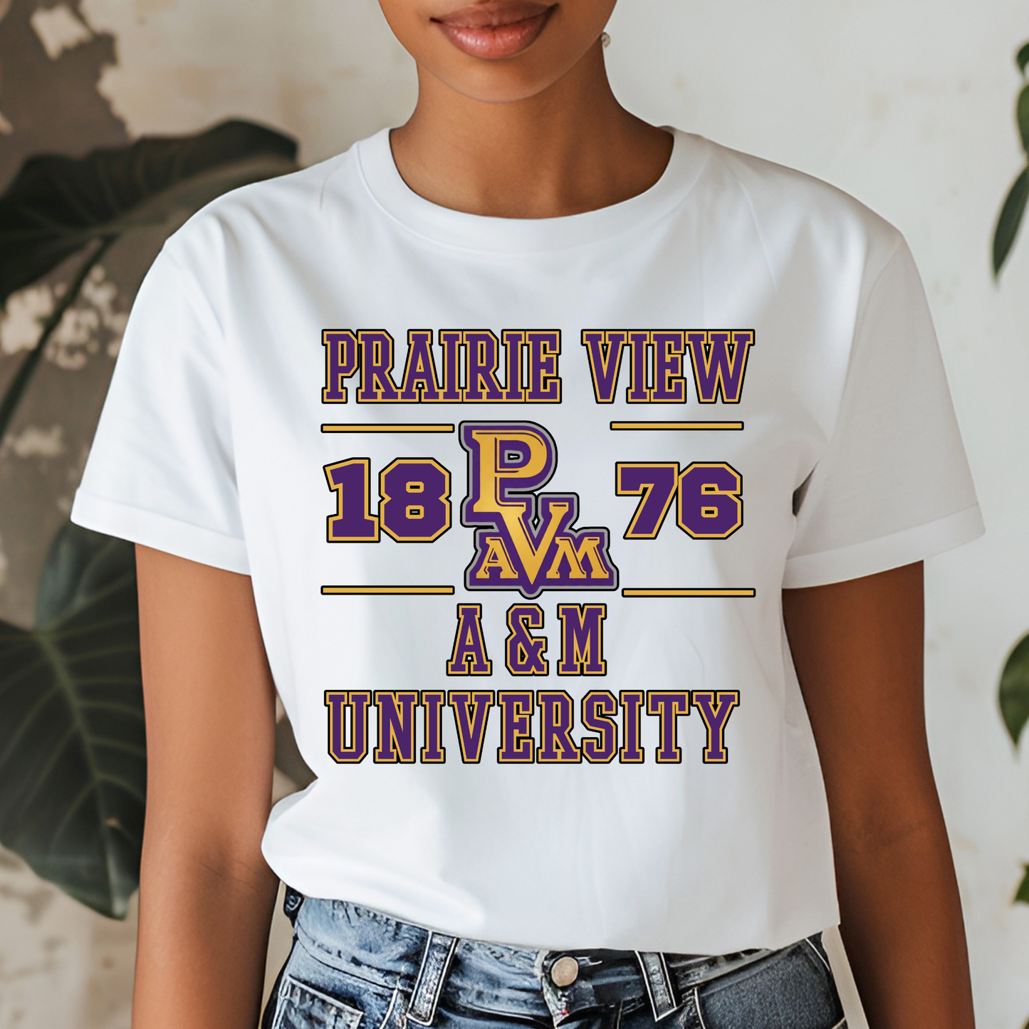 A woman wearing a white graphic t-shirt with purple and gold text that reads 'PRAIRIE VIEW 18 PAV 76 A & M UNIVERSITY'.