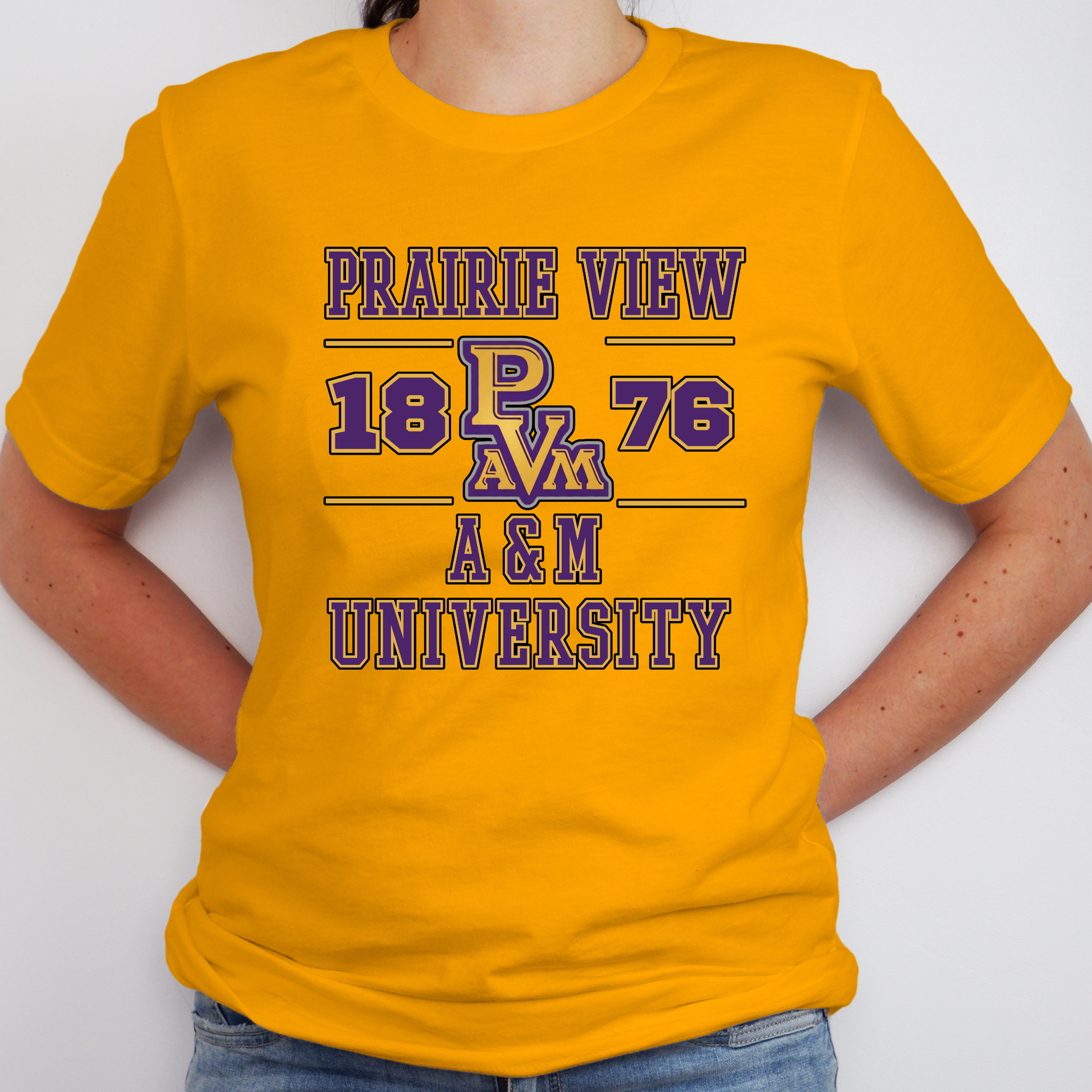 A person wearing a bright yellow short-sleeve t-shirt with a purple and blue graphic print that reads 'PRAIRIE VIEW 18 PAVM 76 A&M UNIVERSITY'.