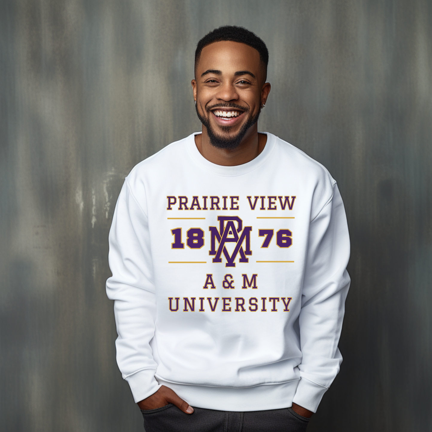 A smiling man wearing a white crewneck sweatshirt with a maroon and purple 'Prairie View 1876 A & M University' graphic, standing against a textured gray background.
