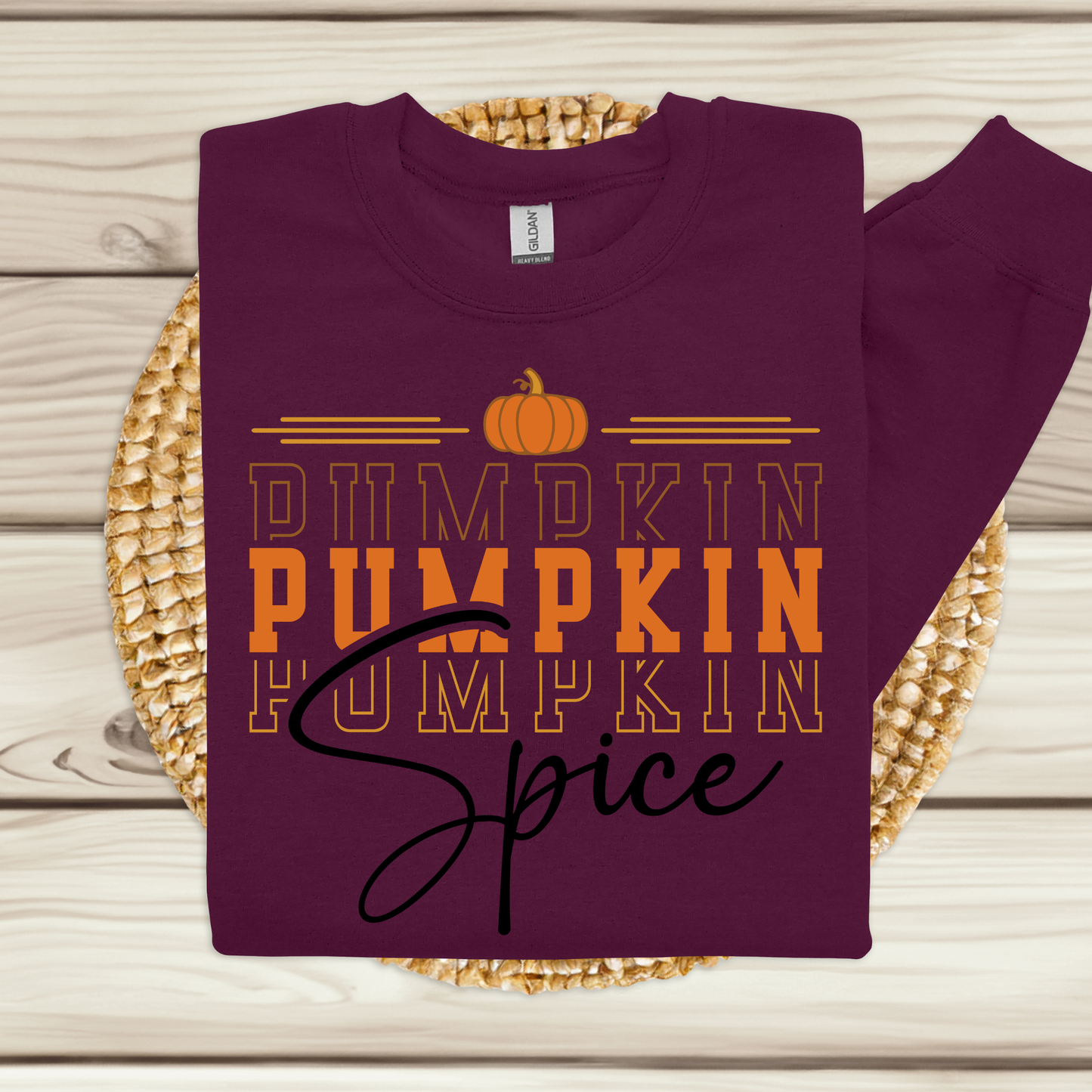 Purple sweatshirt with 'Pumpkin Spice' text on a woven mat