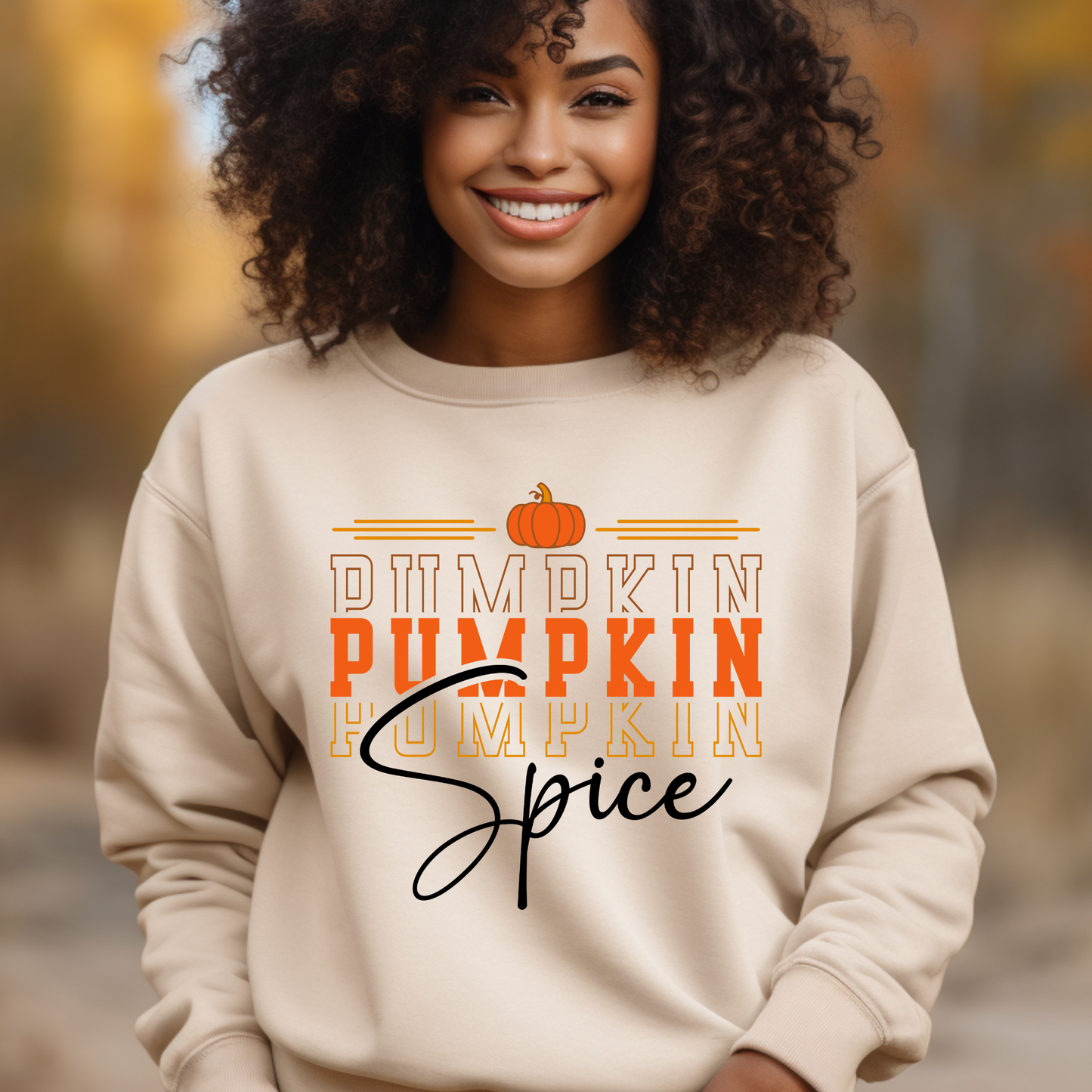 Person wearing a beige sweatshirt with 'Pumpkin Pumpkin Spice' text in an autumn setting