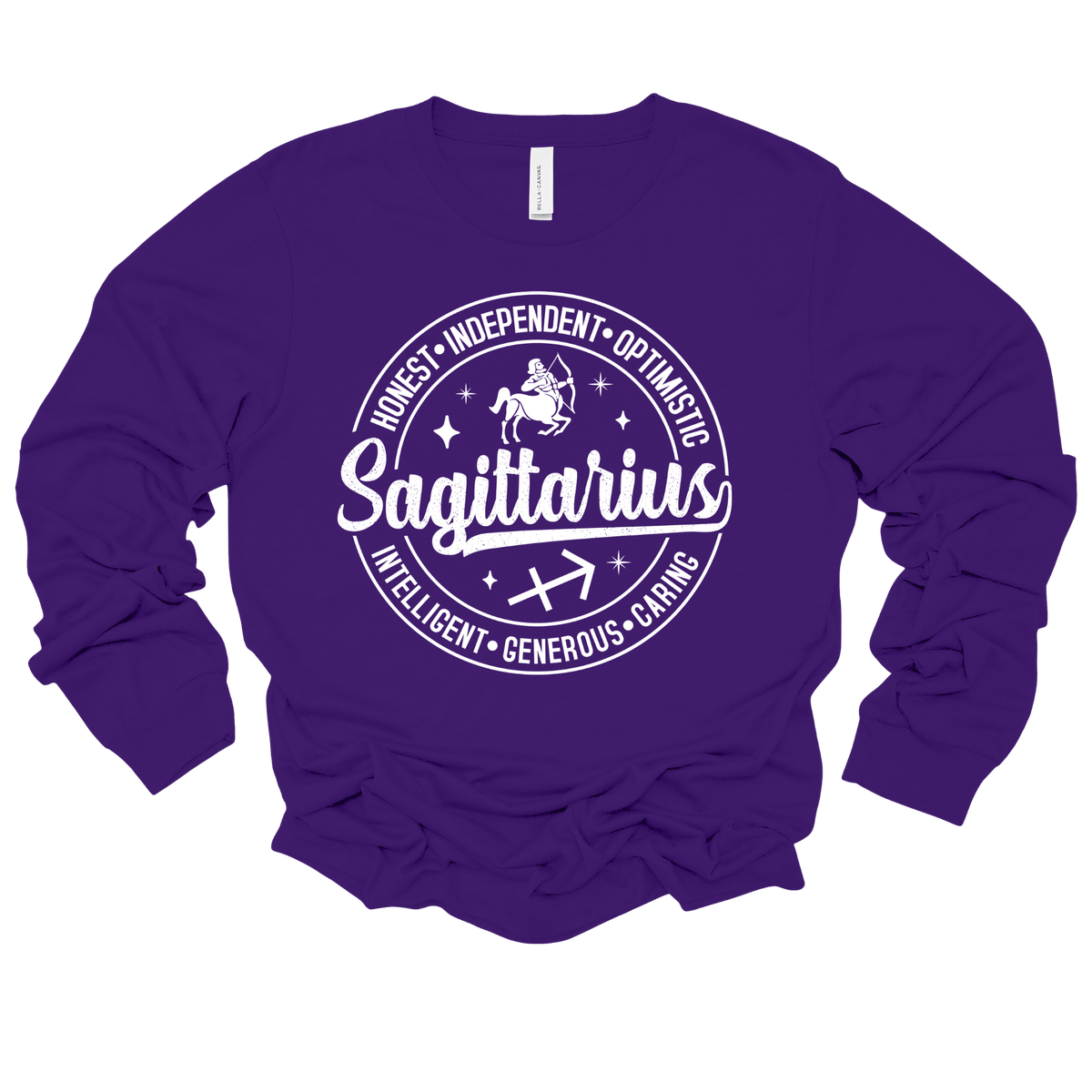 A purple long-sleeve t-shirt with a white graphic print on the front featuring the word 'Sagittarius' inside a circular astrological design with stars and zodiac traits.