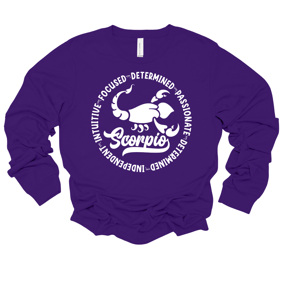 Woman wearing a purple crewneck sweatshirt featuring a white circular Scorpio zodiac graphic with a scorpion illustration, the word "Scorpio," and trait keywords like intuitive, focused, determined, passionate, and independent.