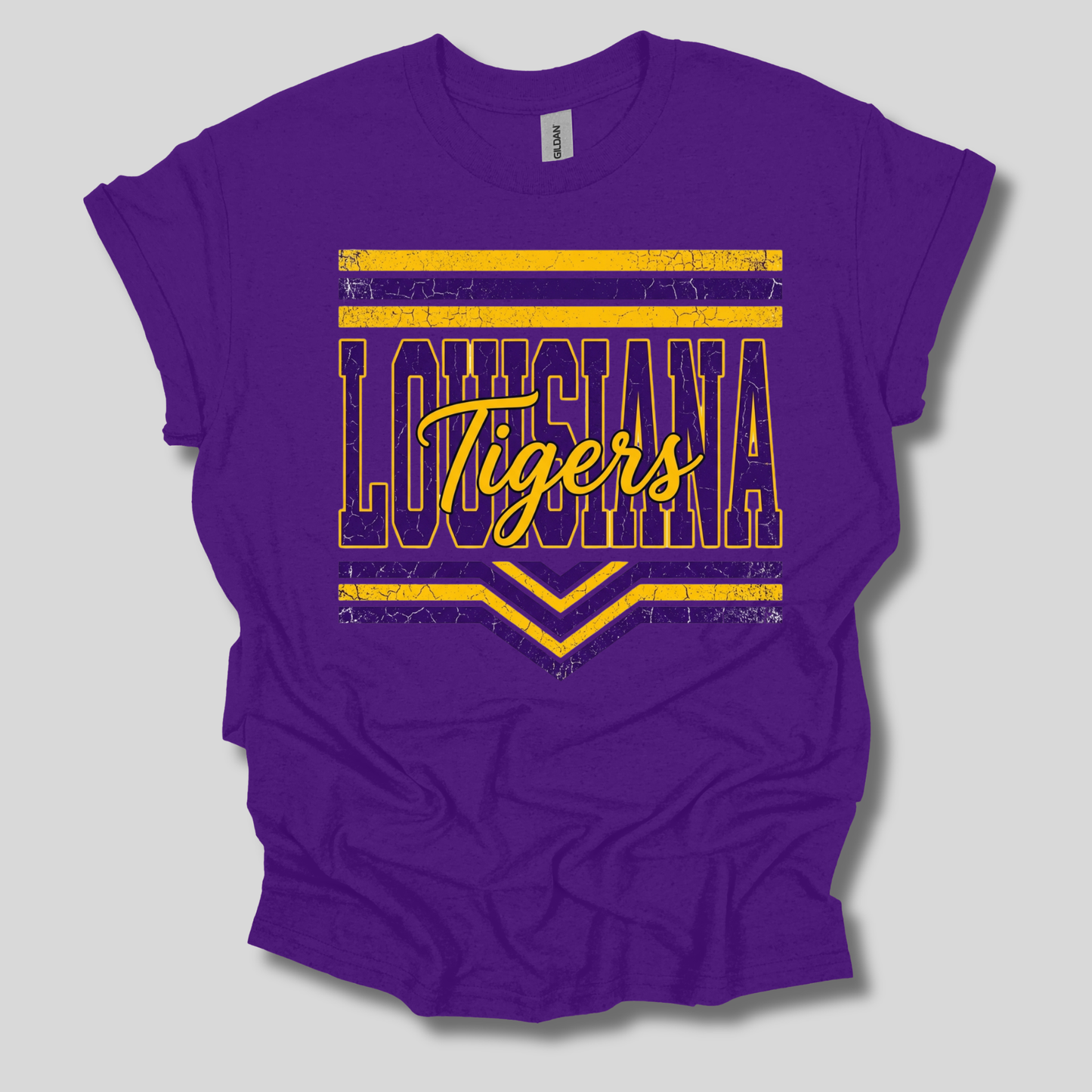 A purple short-sleeve t-shirt with a graphic design on the front. The design features the word 'BENTON' repeated in white outline letters, with a central purple banner reading 'Tigers' in stylized white and yellow lettering, accented by two small yellow tiger faces.