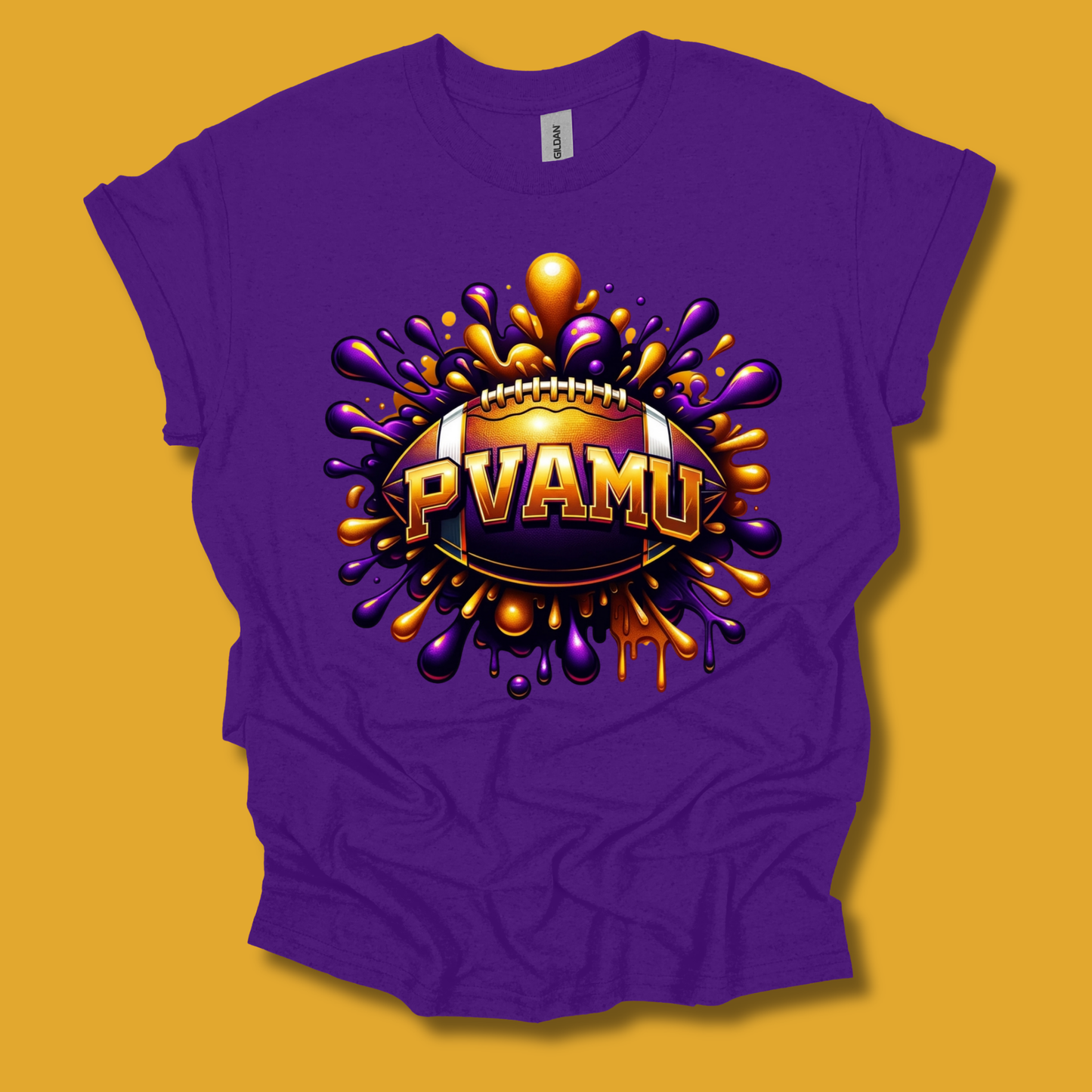 A purple short-sleeve t-shirt with a vibrant graphic print on the front. The graphic features a football surrounded by purple and gold paint splatters, with the text 'PVAMU' in gold letters.
