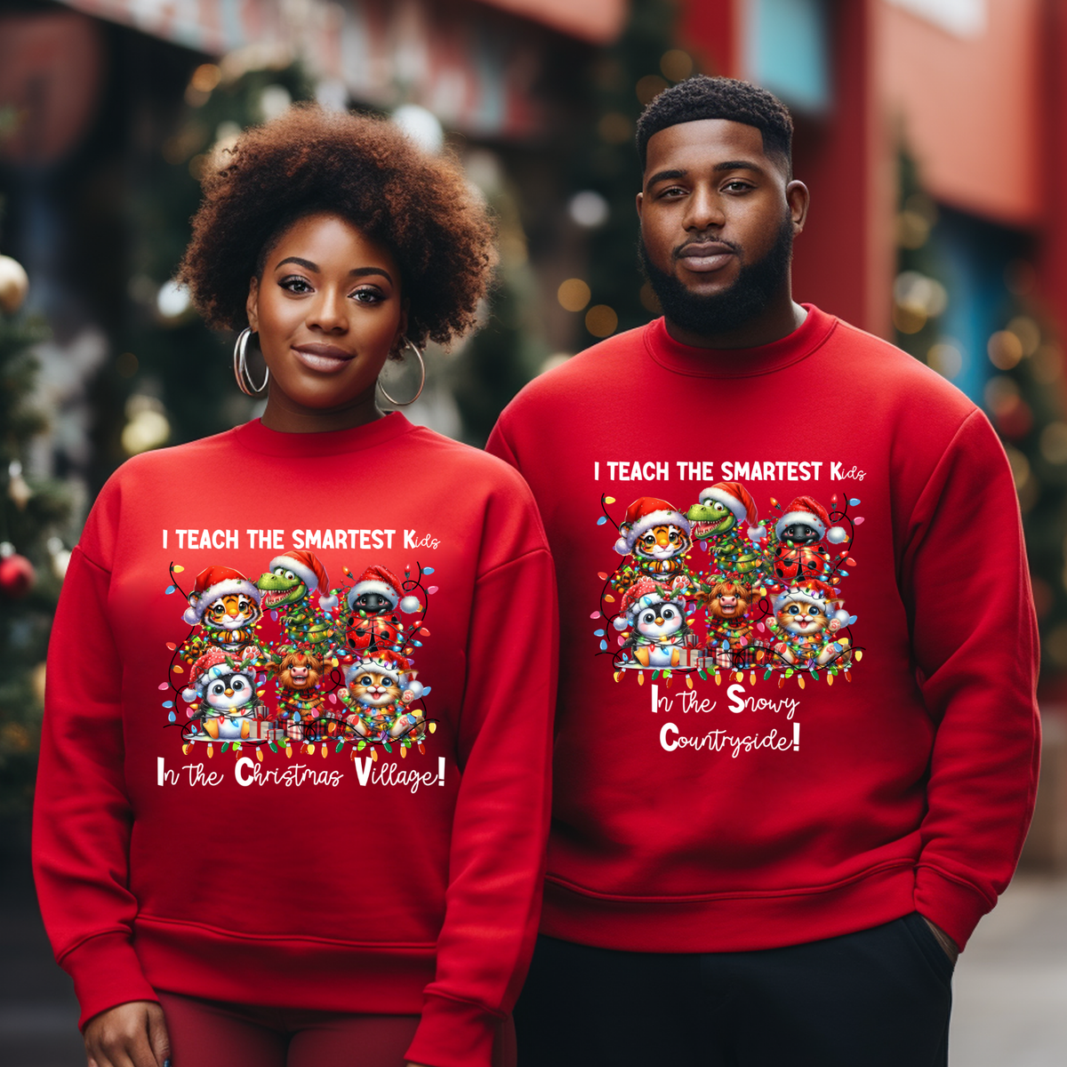 A man and a woman standing together in a festive outdoor holiday setting, both wearing matching red crewneck sweatshirts with a colorful cartoon graphic of penguins and text that reads 'I TEACH THE SMARTEST Kids In the Snow Coozarts!'.