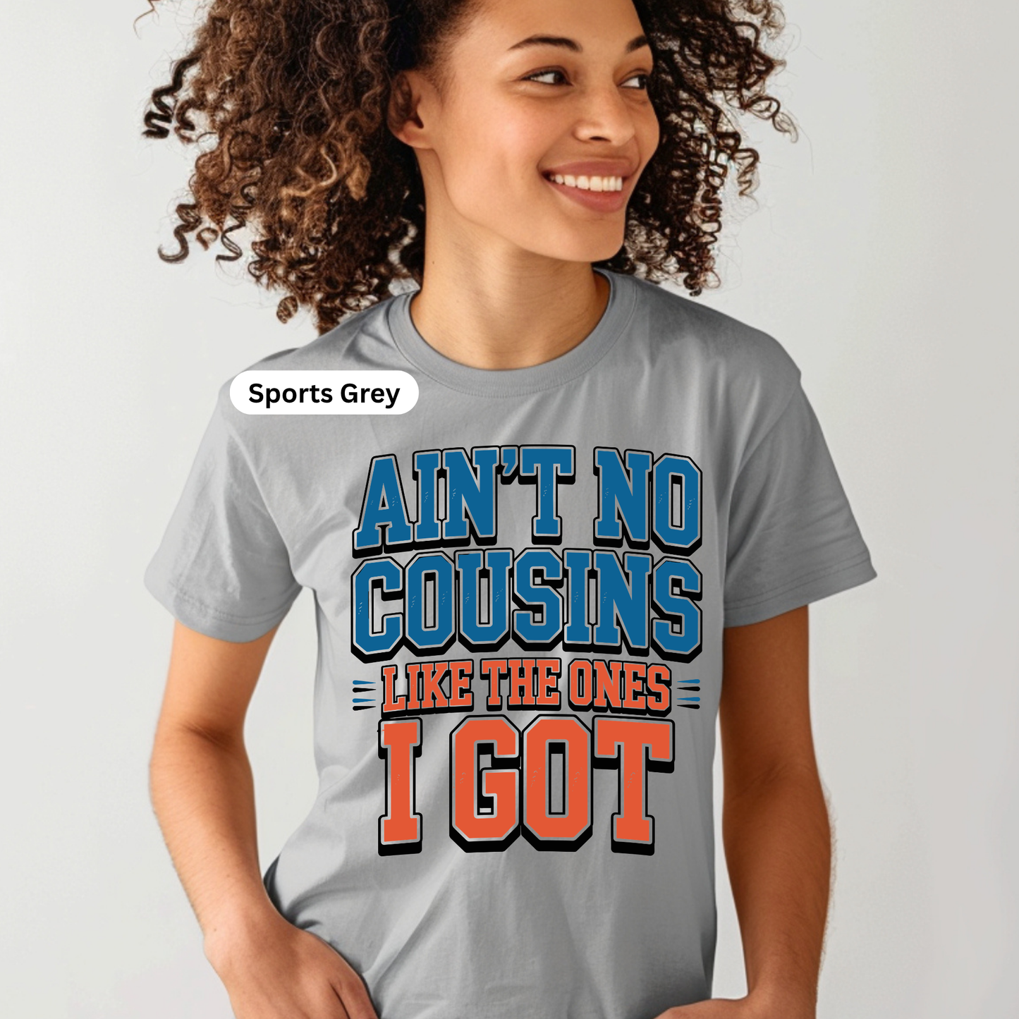 Person wearing a gray t-shirt with colorful text design on a light gray background
