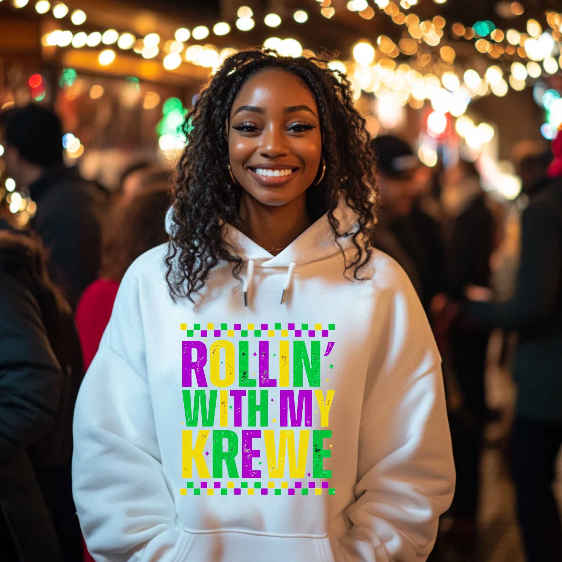 Woman wearing a hoodie with 'Rollin' with my Krewe' text in a festive outdoor setting.