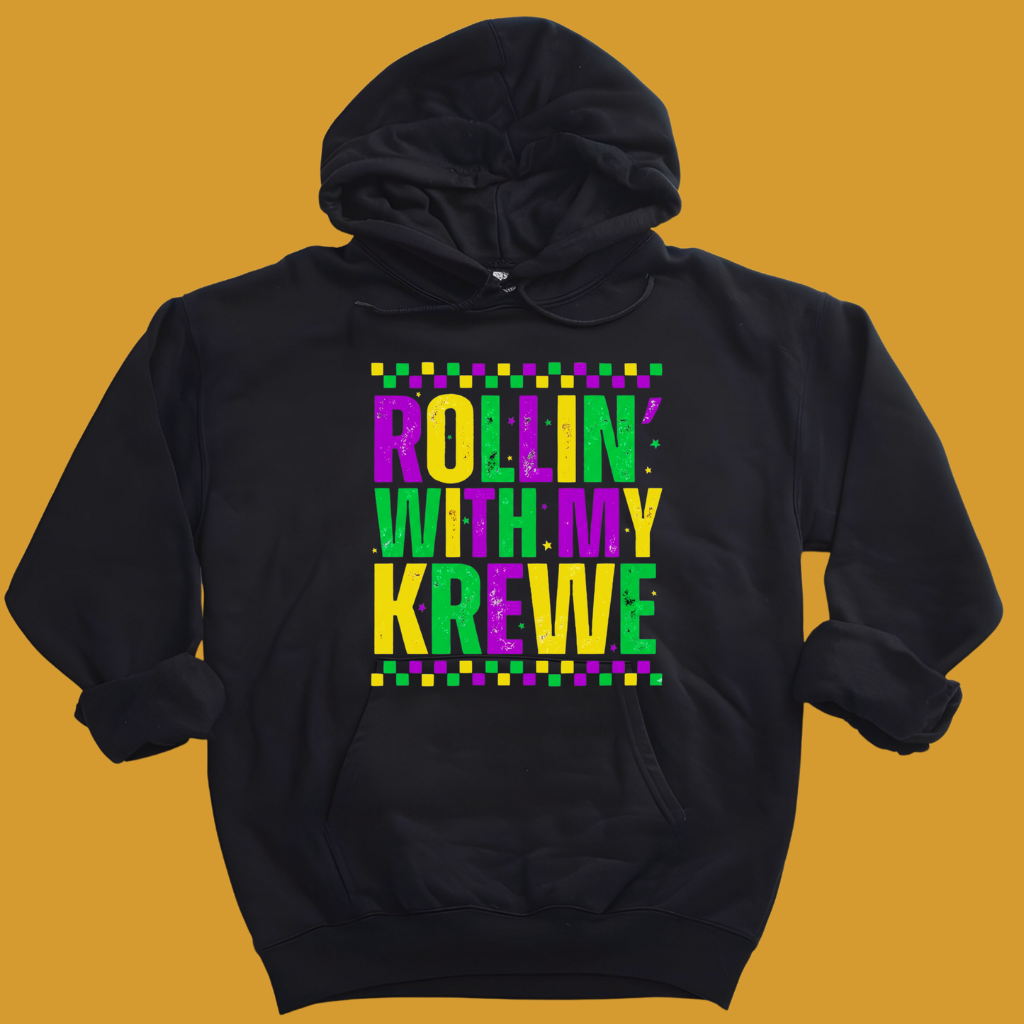 Black hoodie with colorful text 'Rollin with my Krewe' on a mustard yellow background