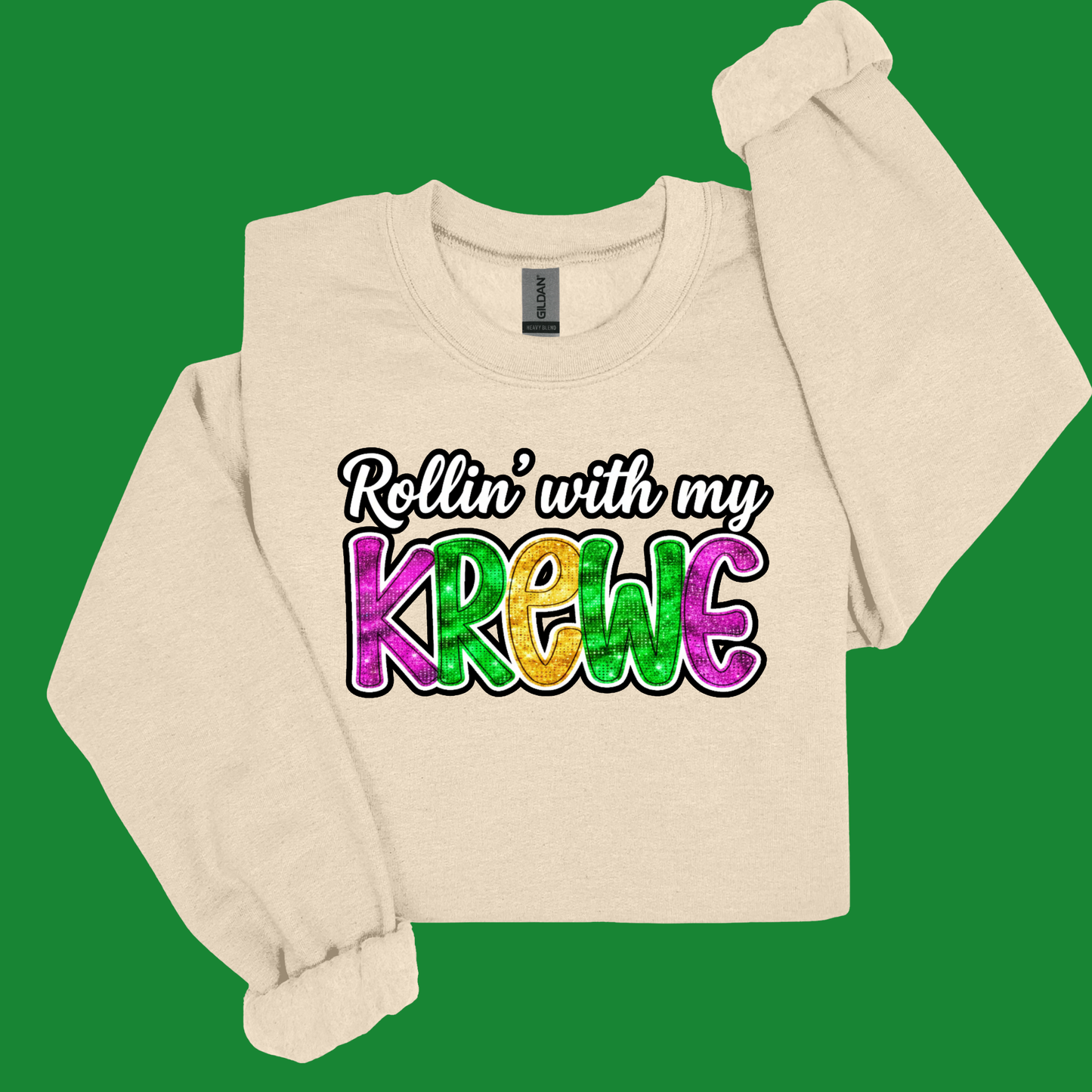 Beige long-sleeve shirt with colorful text 'Rollin' with my Krewe' on a green background