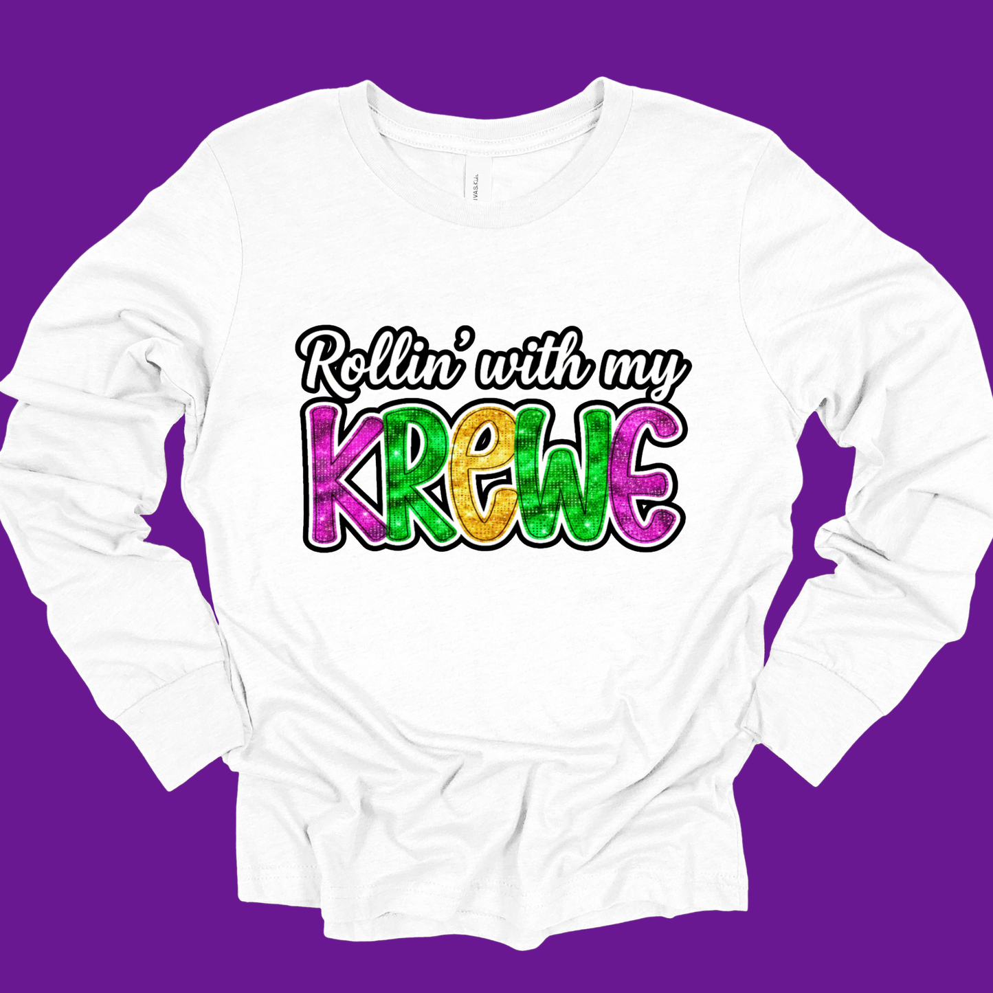 White long-sleeve shirt with colorful text 'Rollin' with my Krewe' on a purple background