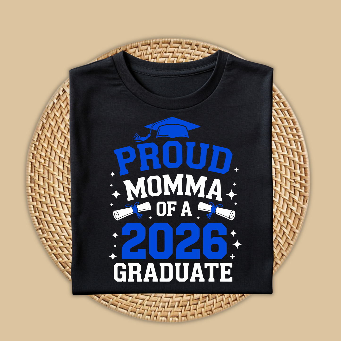 Black t-shirt with 'Proud Momma of a 2026 Graduate' text on a woven mat