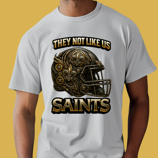 Person wearing a white t-shirt with a helmet graphic and text on a yellow background Saints Mascot Shirt - Saints They Not Like Us Game Day Football Tee