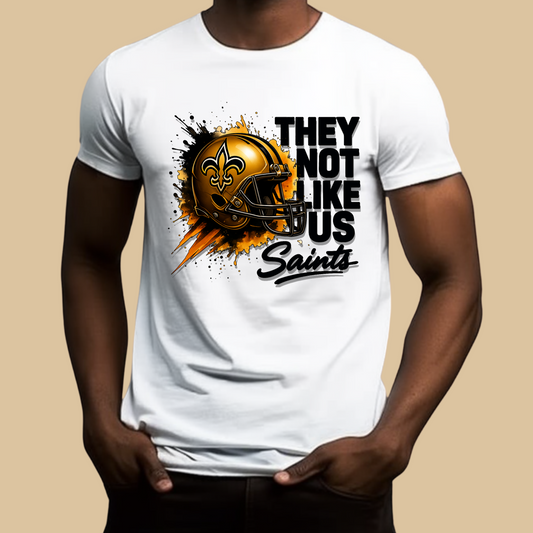White t-shirt with a football helmet graphic and text on a beige background Saints Mascot Shirt - Ultimate Saints Fan They Not Like Us Tee