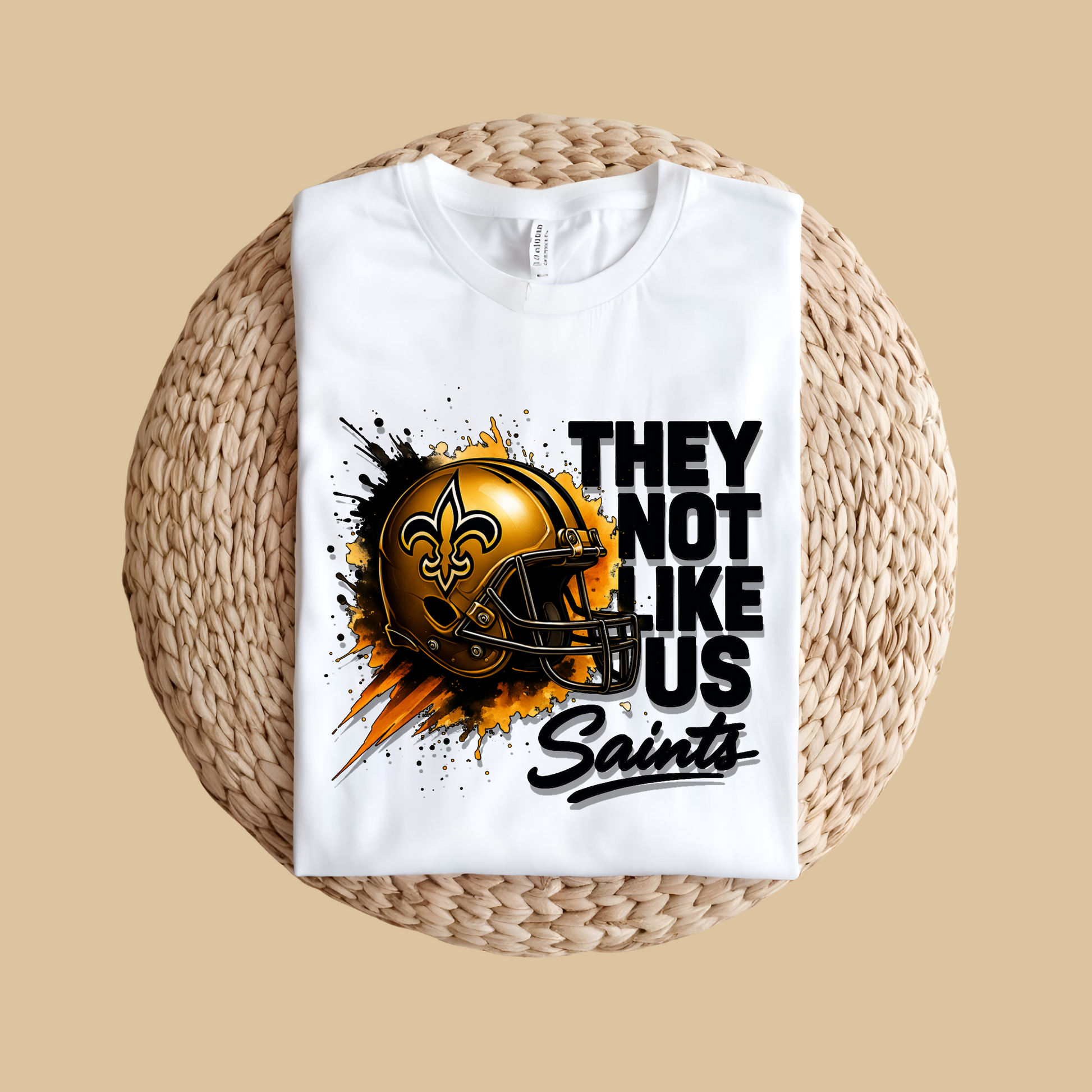 White t-shirt with a football helmet graphic and text on a woven surface Saints Mascot Shirt - Ultimate Saints Fan They Not Like Us Tee