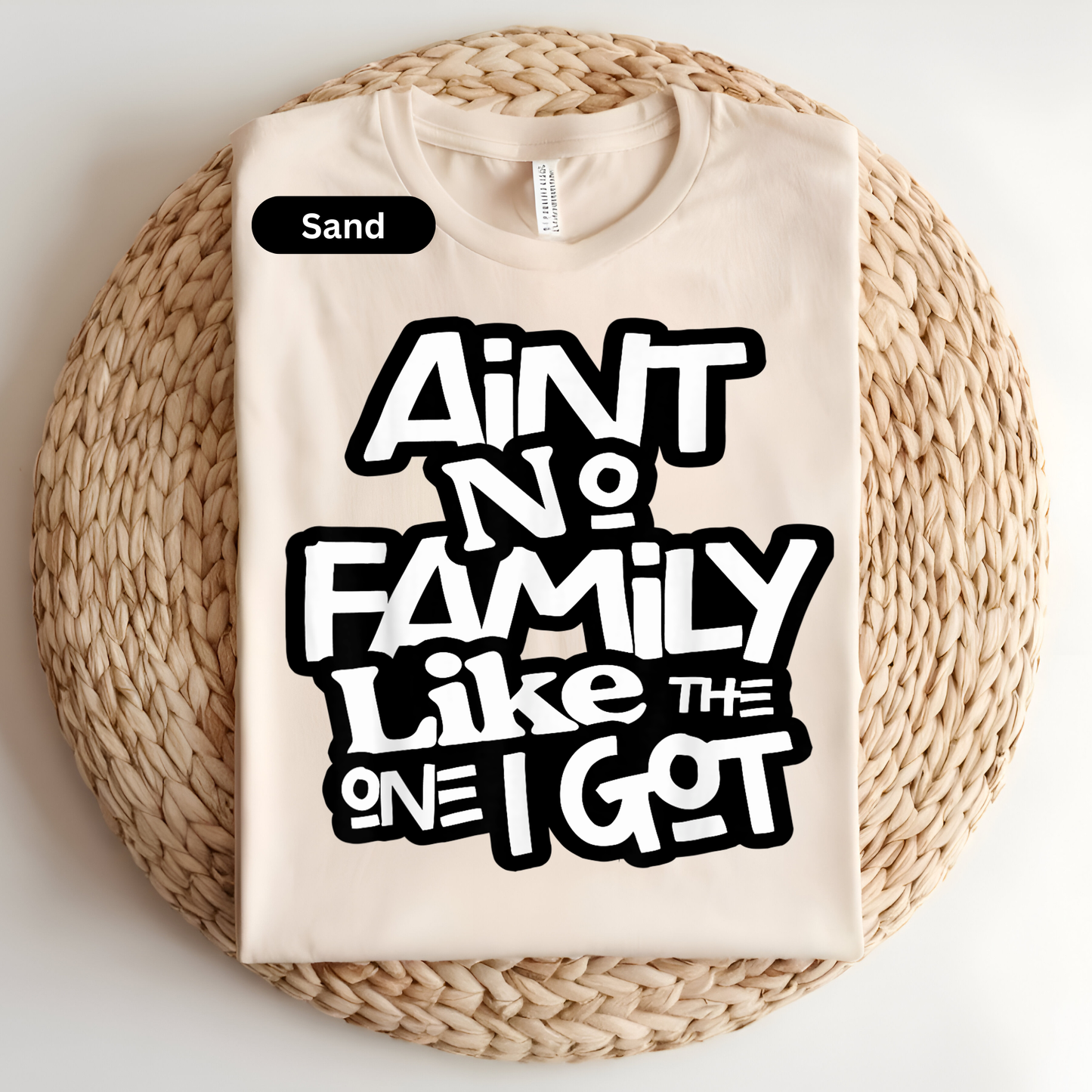 Beige t-shirt with black text on a woven surface