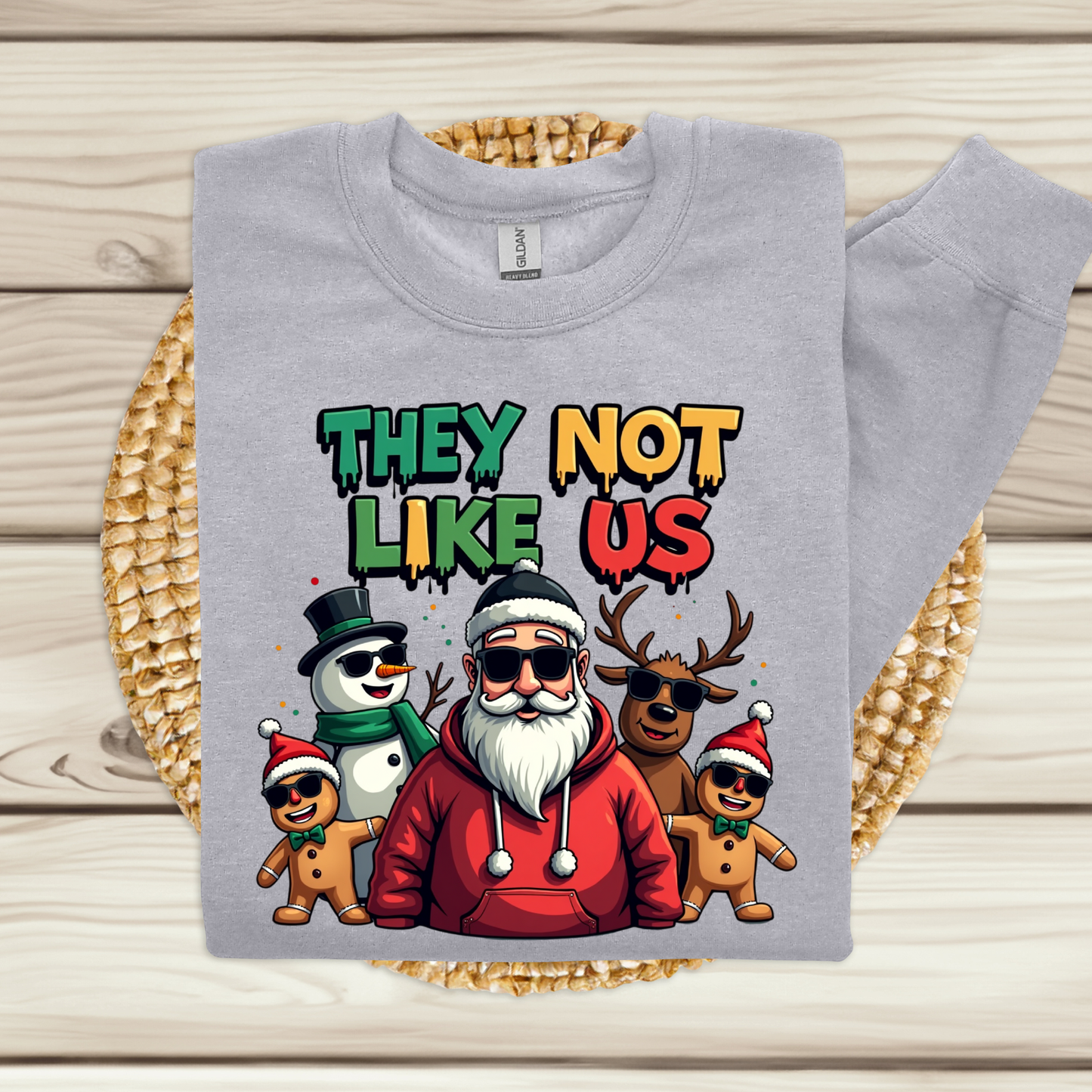 Gray sweatshirt with colorful graphic design featuring Santa Claus and reindeer on a wooden surface.