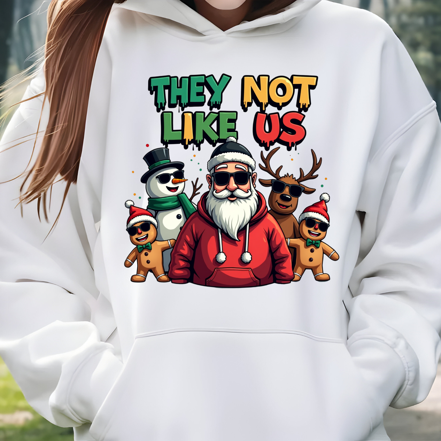 White hoodie with colorful graphic design featuring Santa Claus and other characters, text 'THEY NOT LIKE US'.