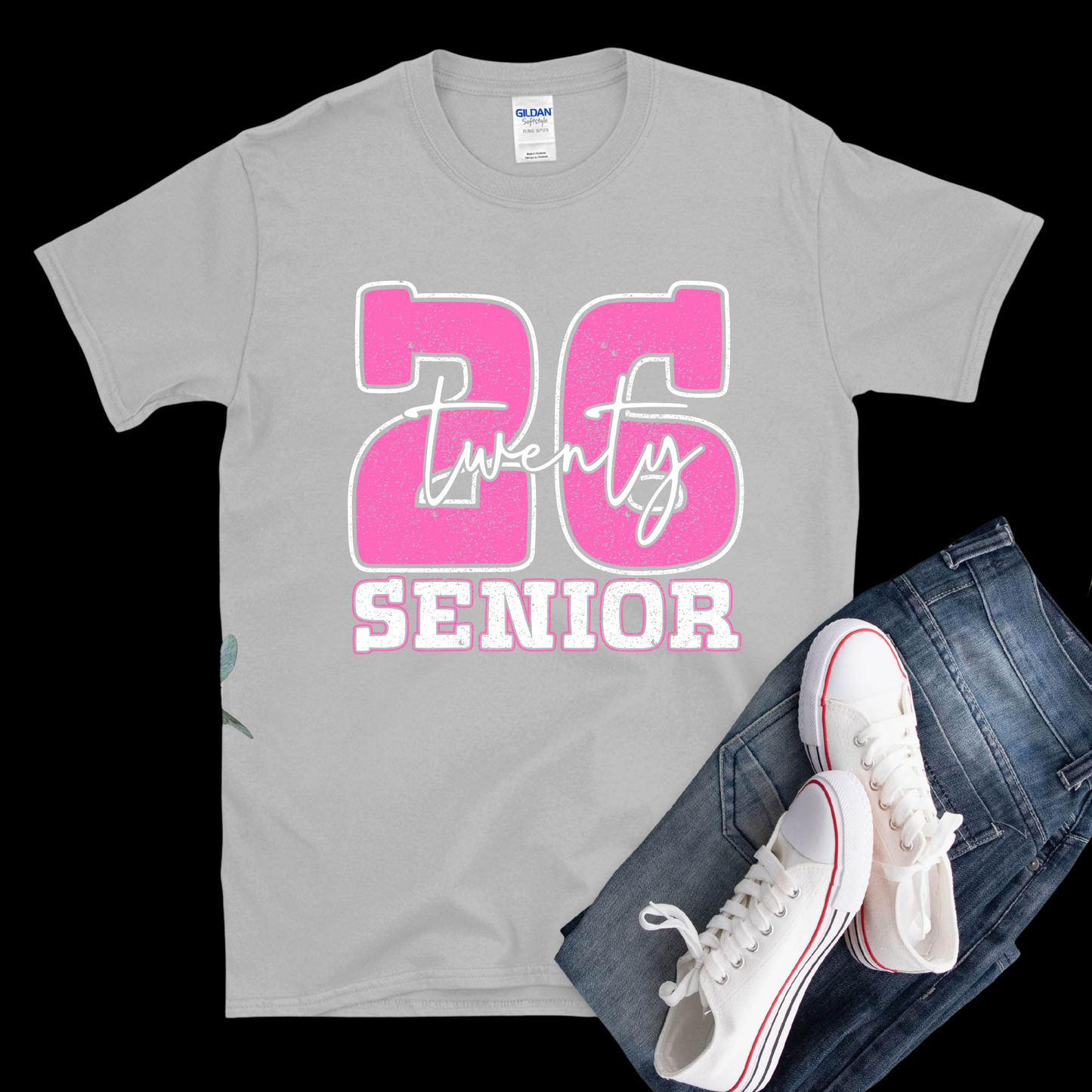 Gray t-shirt with pink '26 Senior' design, white sneakers, and blue jeans on a black background