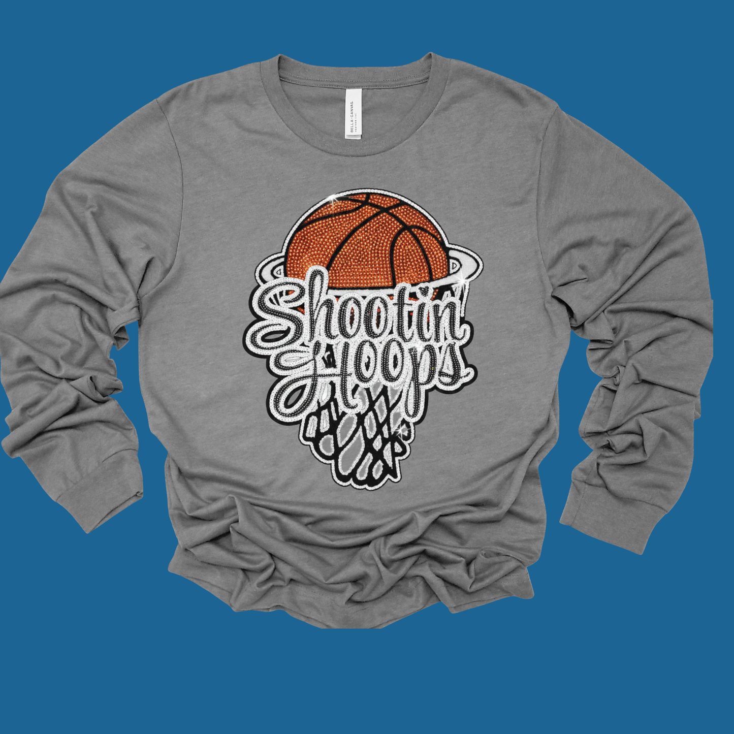 Gray long-sleeve shirt with a basketball graphic and 'Shooting Hoops' text on a blue background
