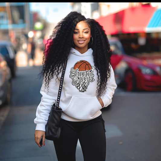 Woman wearing a white hoodie with a graphic design on a city street