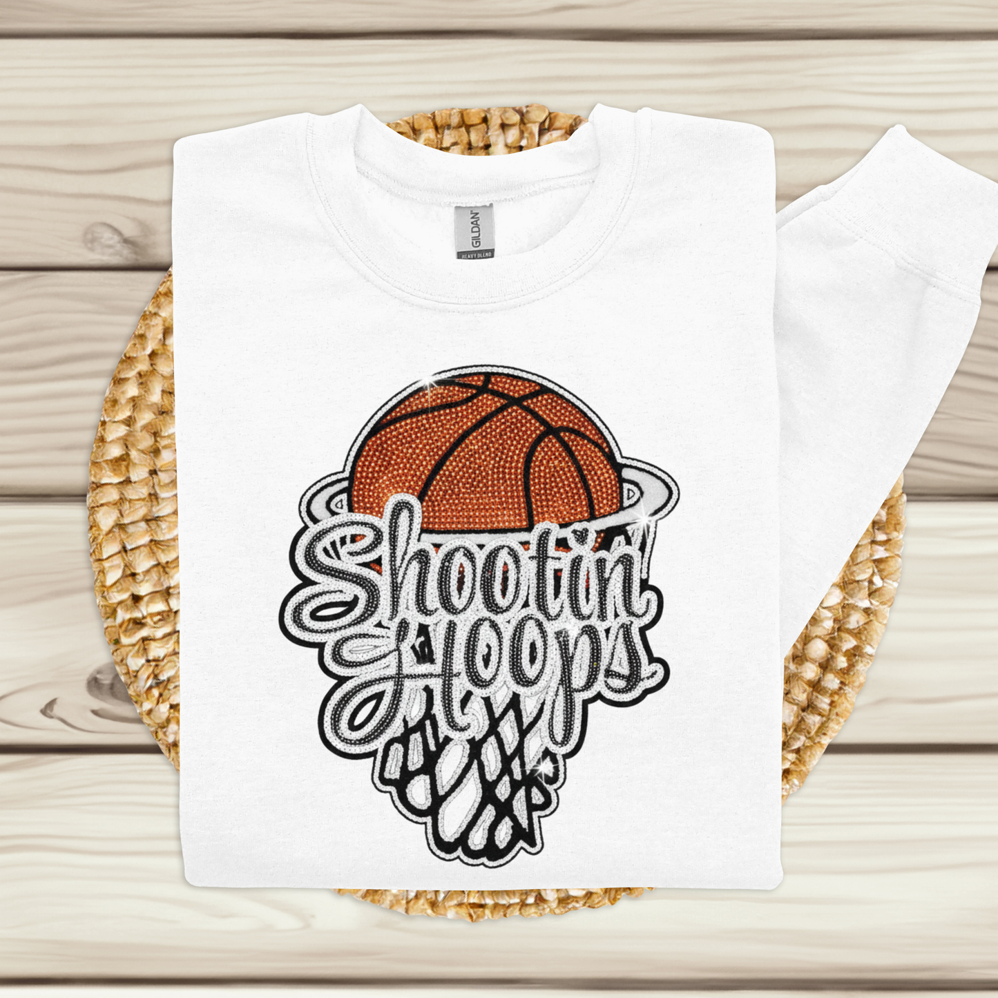 White t-shirt with a basketball graphic and 'Shootin' Hoops' text on a woven mat.