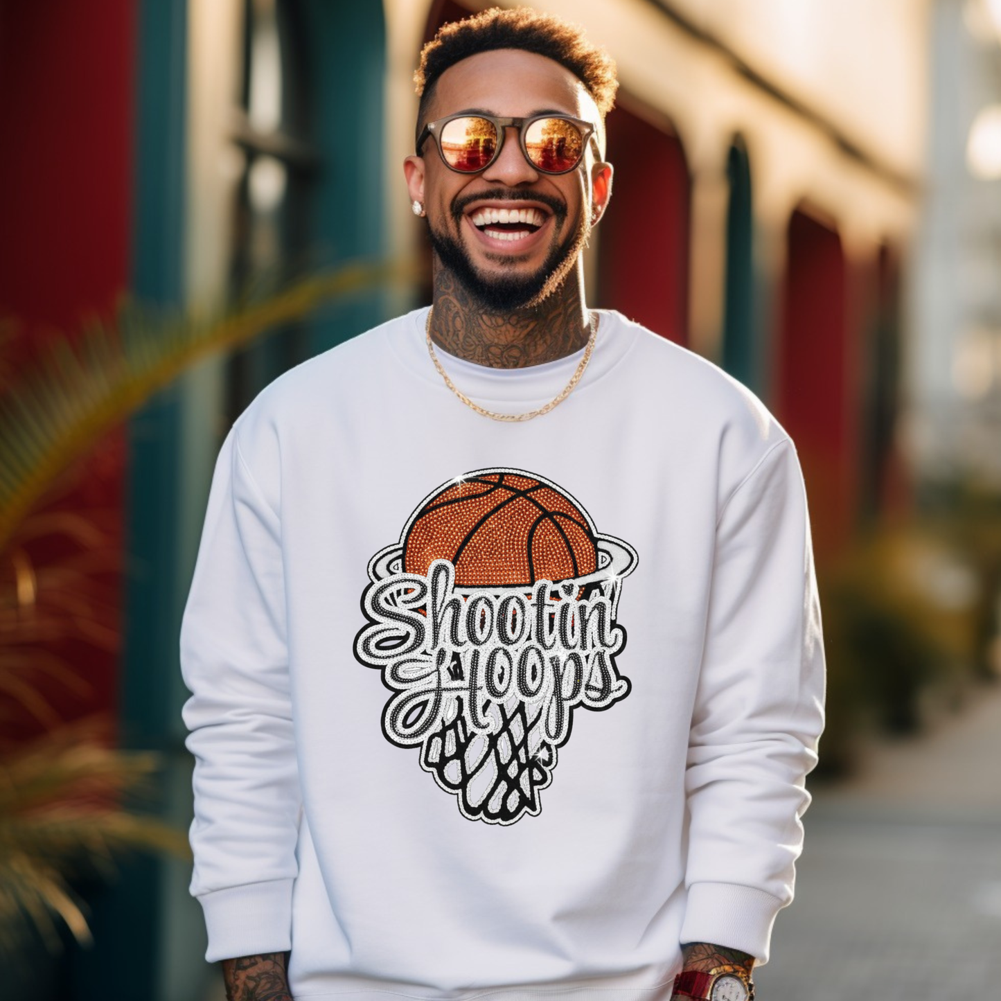 Man wearing a white sweatshirt with a basketball design and text, standing outdoors.