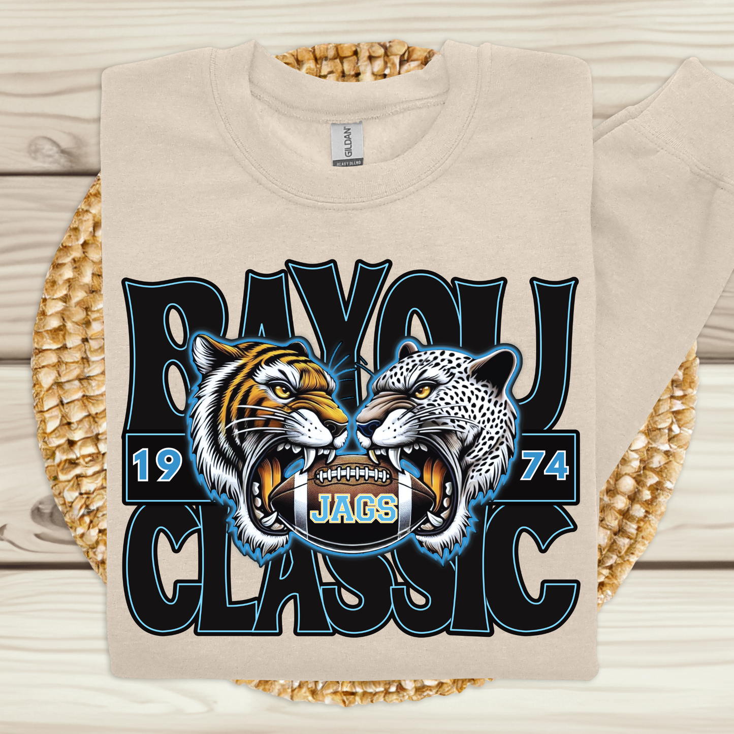 Beige sweatshirt with a graphic of two roaring animals and text on a wooden surface