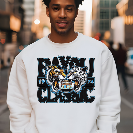 Man wearing a white sweatshirt with a graphic design of two roaring animals and text on a city street background.  Southern Jags Bayou Classic Apparel - Tailgating T-Shirt, Hoodie & Sweater