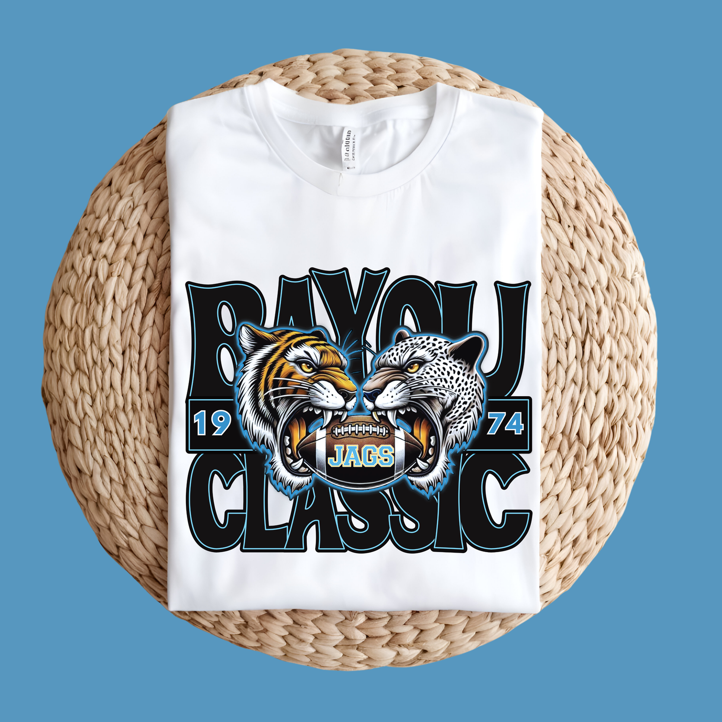 White t-shirt with tiger and panther design and 'Bayou Classic' text on a woven surface.