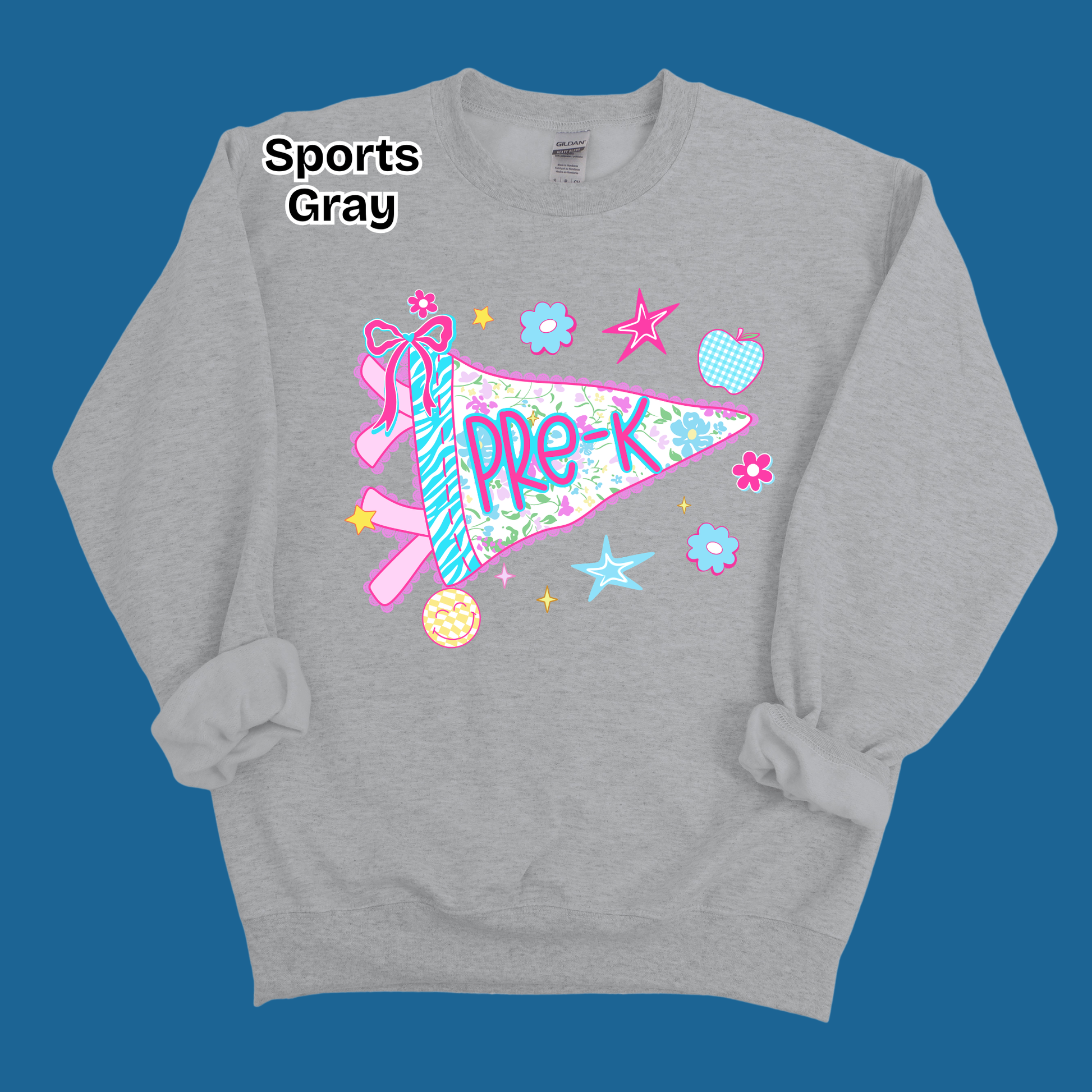 A heather gray crewneck sweatshirt with a colorful 'Pre-K' sports pennant graphic on the front, displayed against a solid blue background. The text 'Sports Gray' is printed in black near the upper left chest area.