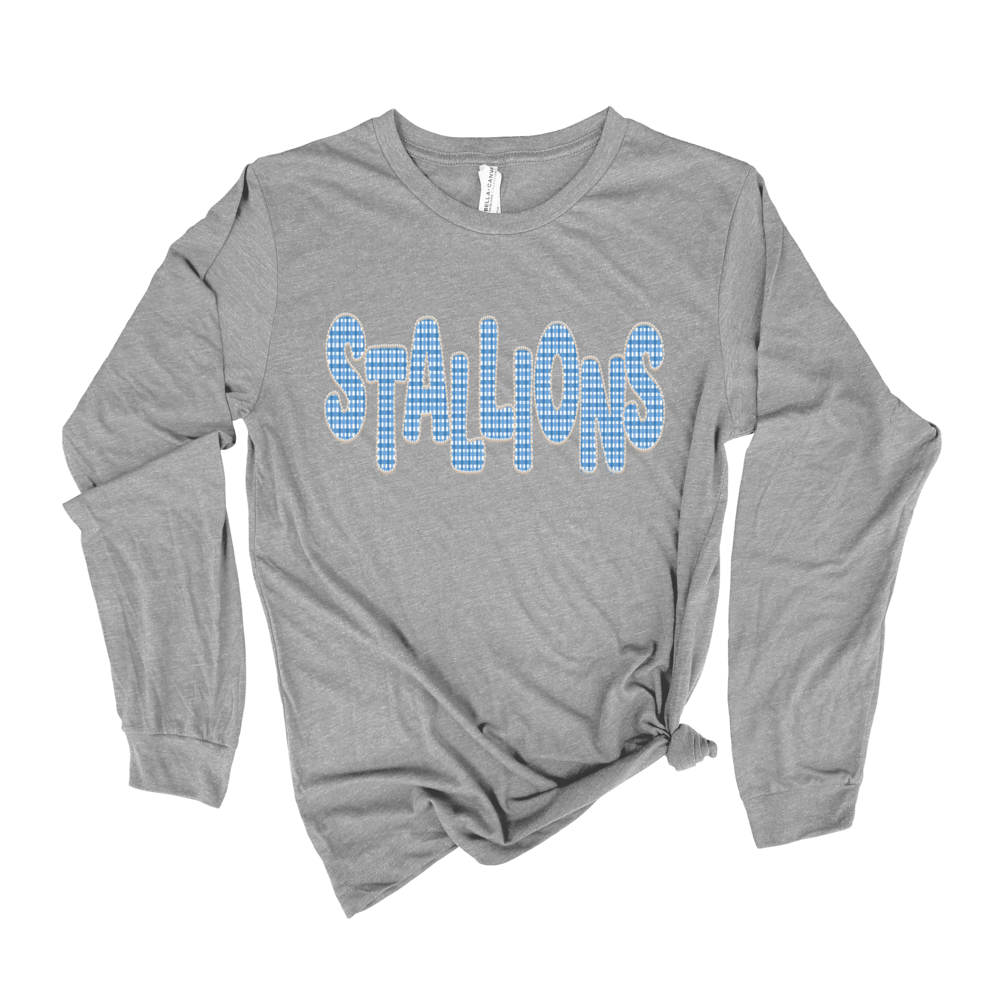 A heather gray long-sleeve t-shirt with 'STALLIONS' printed across the chest in a blue-and-white checkered pattern, styled with a knot at the bottom hem on a white background.
