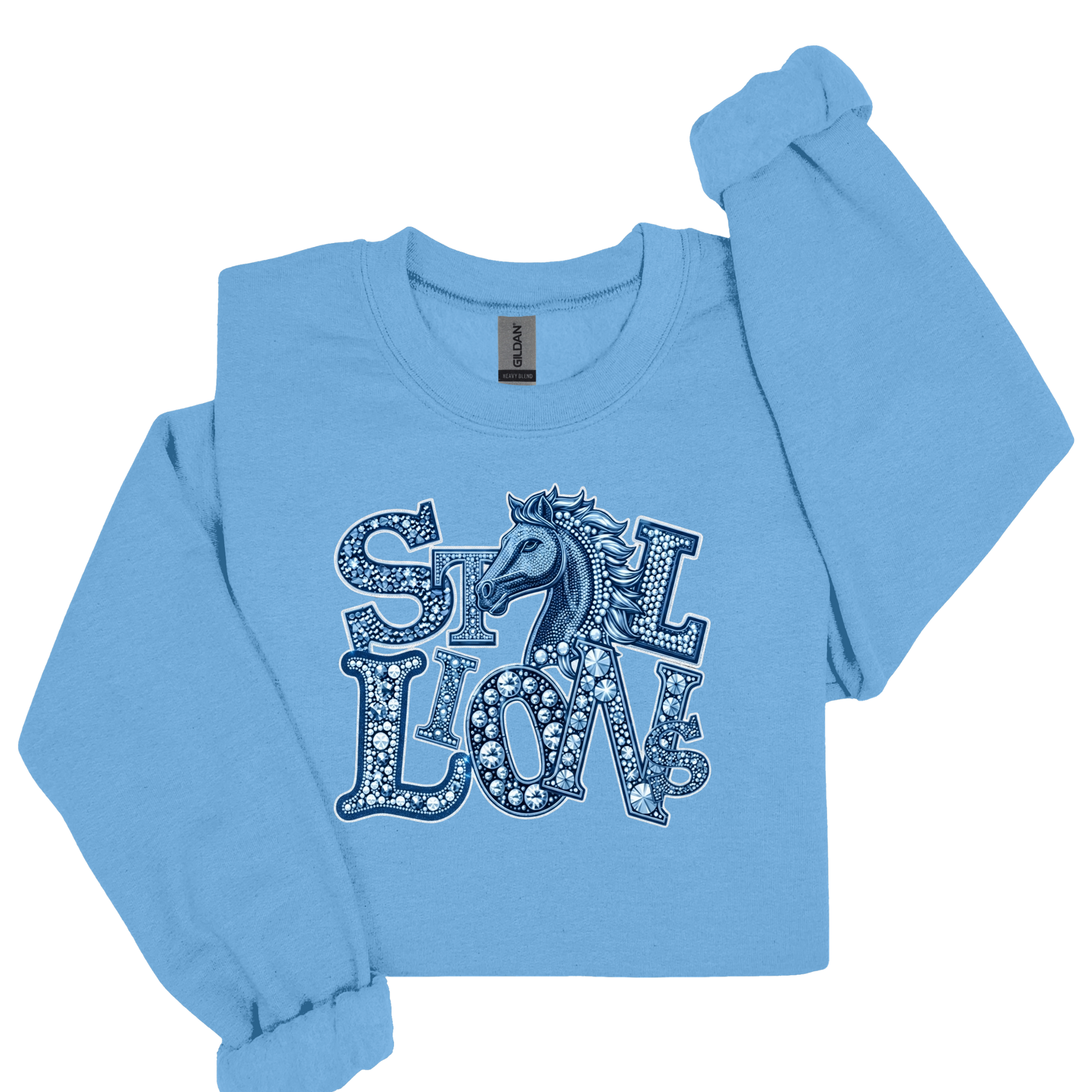 A light blue long-sleeve crewneck sweatshirt featuring a graphic print of the word 'STILL LOVE' in decorative letters with a horse silhouette in the center, displayed on a clean white background.