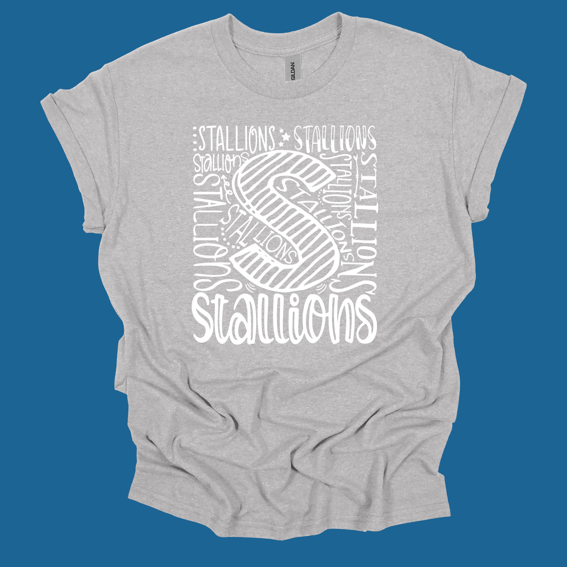 A light heather gray t-shirt with a white graphic print featuring a large stylized letter 'S' and the word 'STALLIONS' repeated in various fonts, shown against a solid blue background.