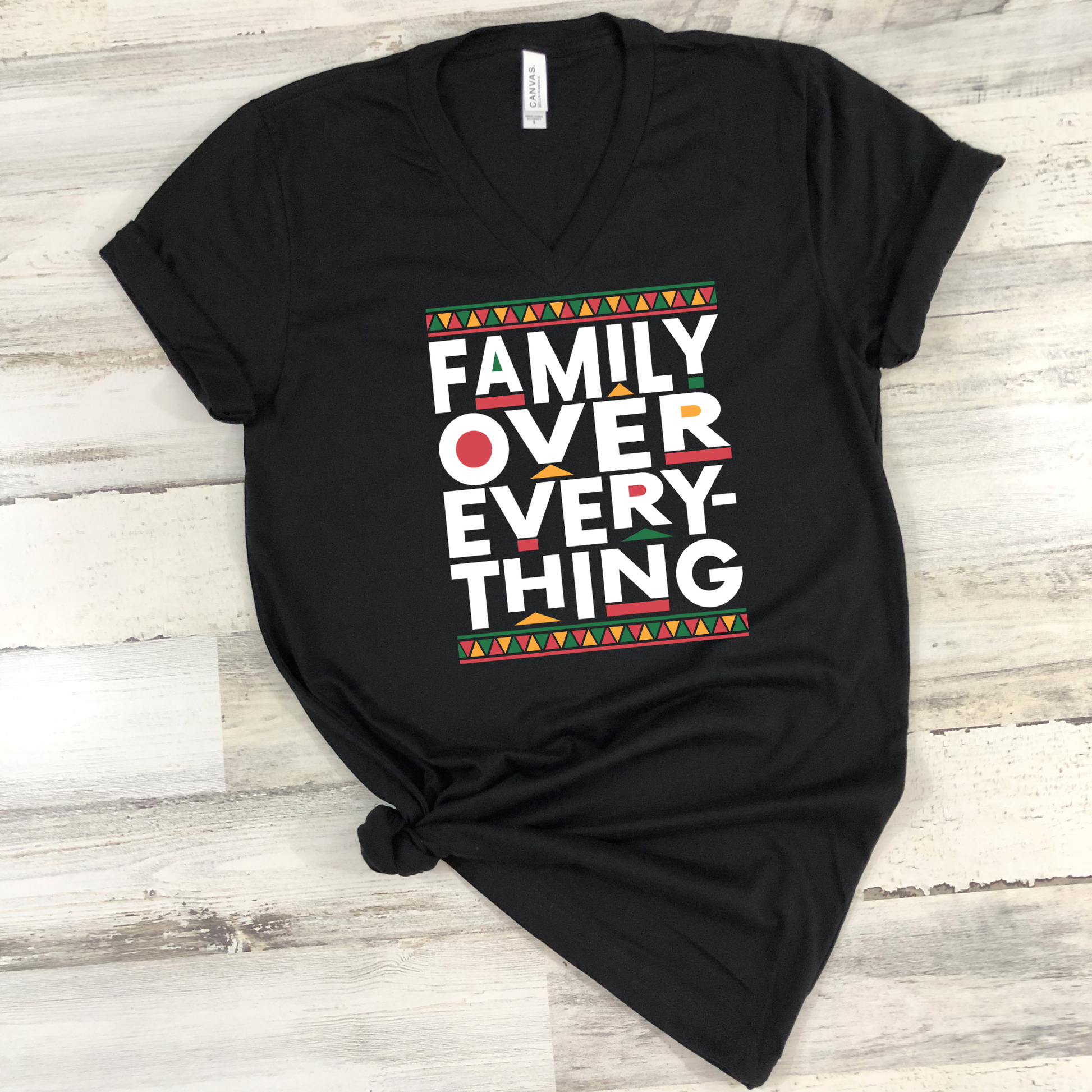 Black t-shirt with 'Family Over Everything' text on a wooden surface