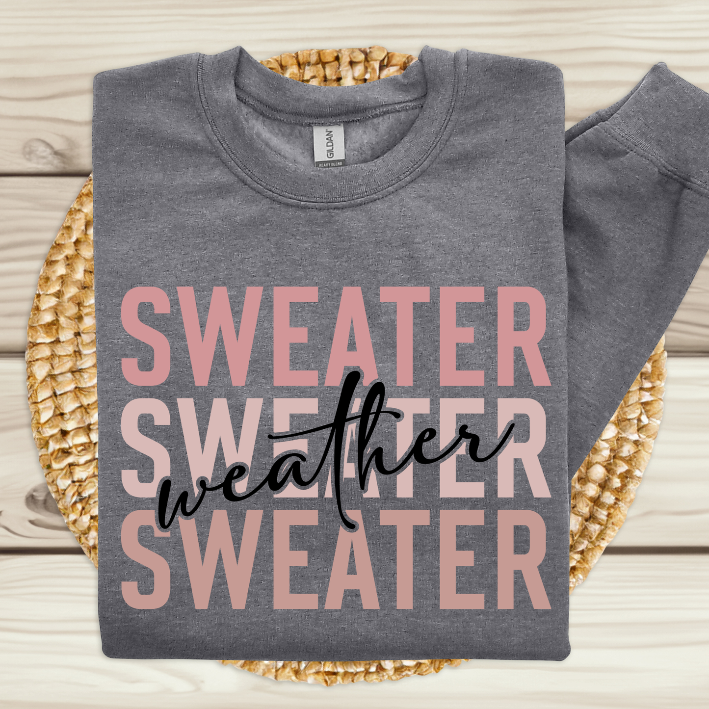 Gray sweatshirt with 'Sweater Weather' text on a woven mat  Sweater Weather - Cute and Chic Minimalist Fall Crewneck Cozy Sweater
