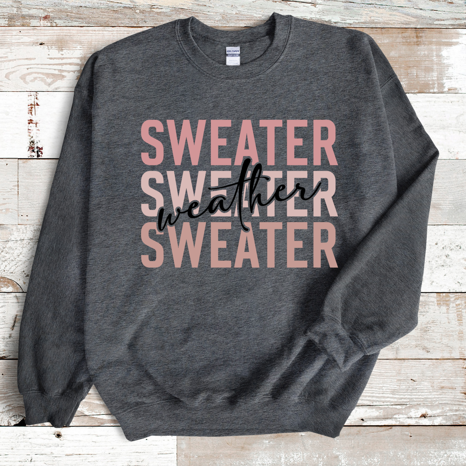 Gray sweatshirt with 'Sweater Weather' text on a wooden surface  Sweater Weather - Cute and Chic Minimalist Fall Crewneck Cozy Sweater