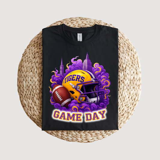Black t-shirt with a football helmet and 'Tigers Game Day' design on a woven mat. Tigers Game Day Tee - Bold Fan Game Day Tigers Football T-Shirt