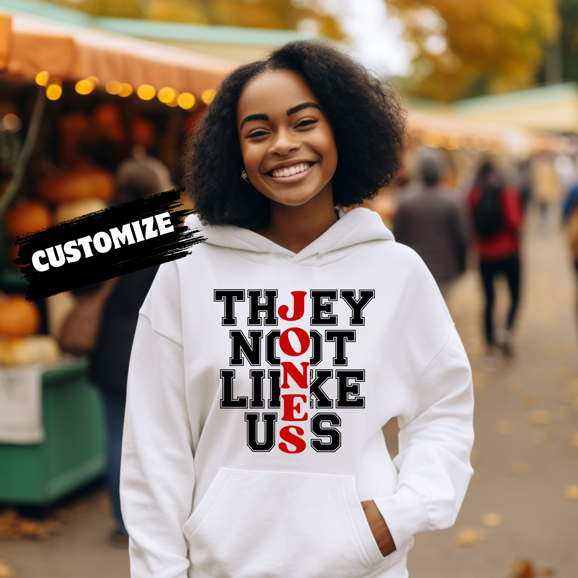 Person wearing a white hoodie with text at an outdoor market.  Family Reunion Hoodie - They Not Like Us - Custom Family Name Matching Hoodie