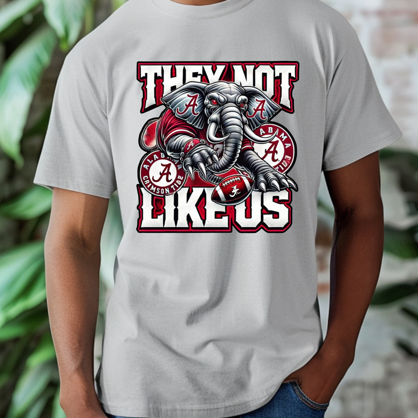 Gray t-shirt with an elephant graphic and text on a blurred background Alabama Football "They Not Like Us" Alabama Crimson Tide T-Shirt