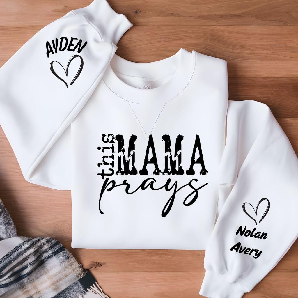 Women wearing This mama prays olive green sweater emphasing a praying mama, a spiritual mama, a religious mama Sweatshirt with personalized children's name on the sleeve

