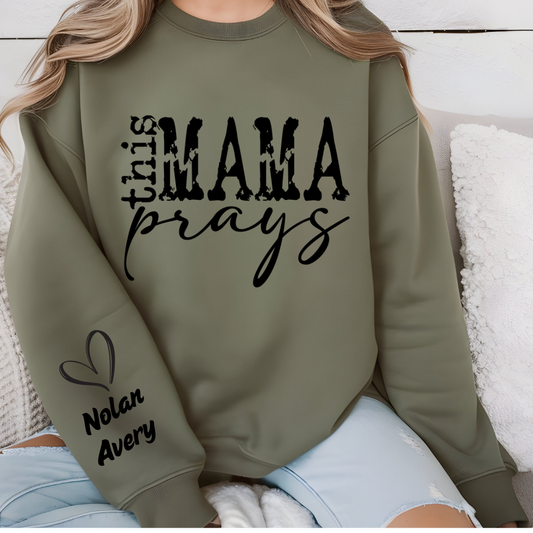 Women wearing This mama prays olive green sweater emphasing a praying mama, a spiritual mama, a religious mama Sweatshirt with personalized children's name on the sleeve
