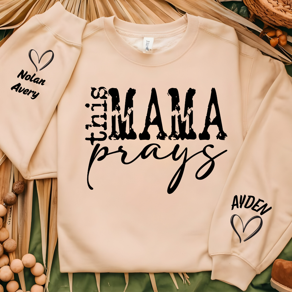 Women wearing This mama prays olive green sweater emphasing a praying mama, a spiritual mama, a religious mama Sweatshirt with personalized children's name on the sleeve which is a perfect mother's day gift for mom