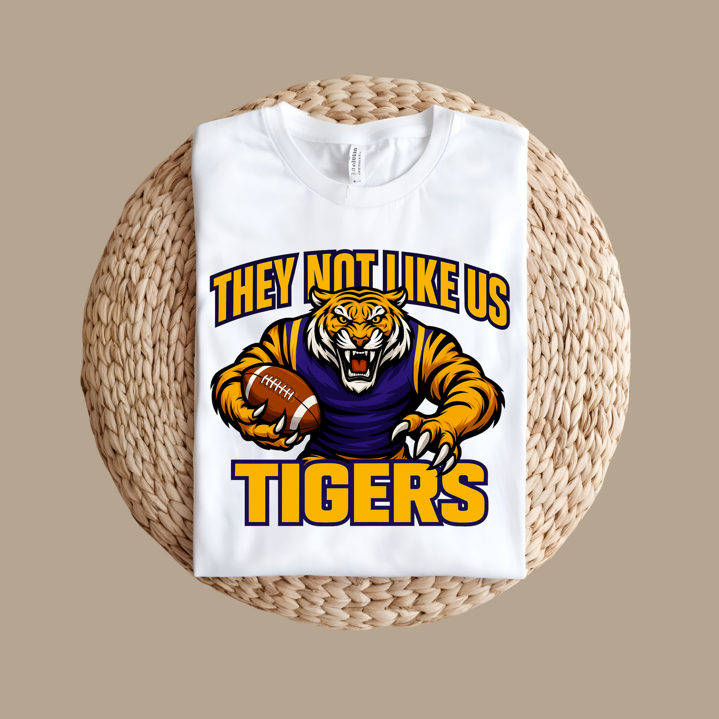 White sweatshirt with tiger graphic and text on a woven surface Tigers Mascot T-shirt - Tigers They Not Like Us Game Day Spirit Tee