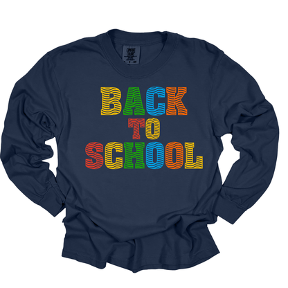 A navy blue long-sleeve t-shirt with a colorful graphic reading 'BACK TO SCHOOL' in rainbow-striped letters, displayed flat against a white background.