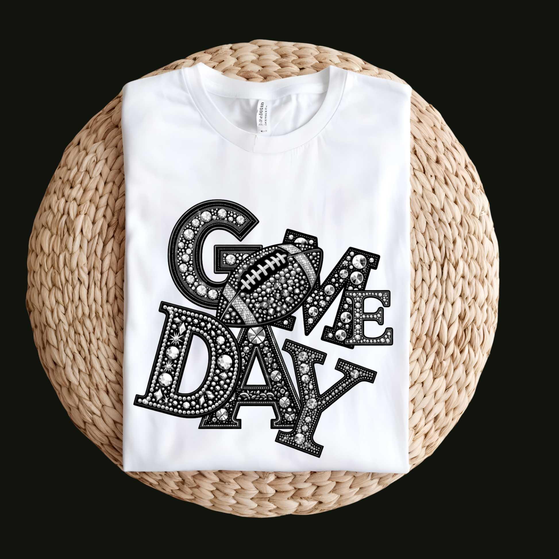 A white short-sleeve T-shirt laid flat on a round woven straw mat against a black background. The shirt has a large front graphic reading “WE ARE Bulldogs” in distressed red, black, and white lettering.