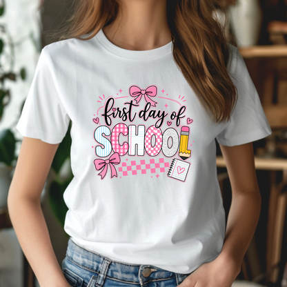 A woman wearing a white short-sleeve t-shirt with a colorful 'Kinder garten' graphic print featuring school and kindergarten-themed illustrations like an apple, pencil, bus, and globe.