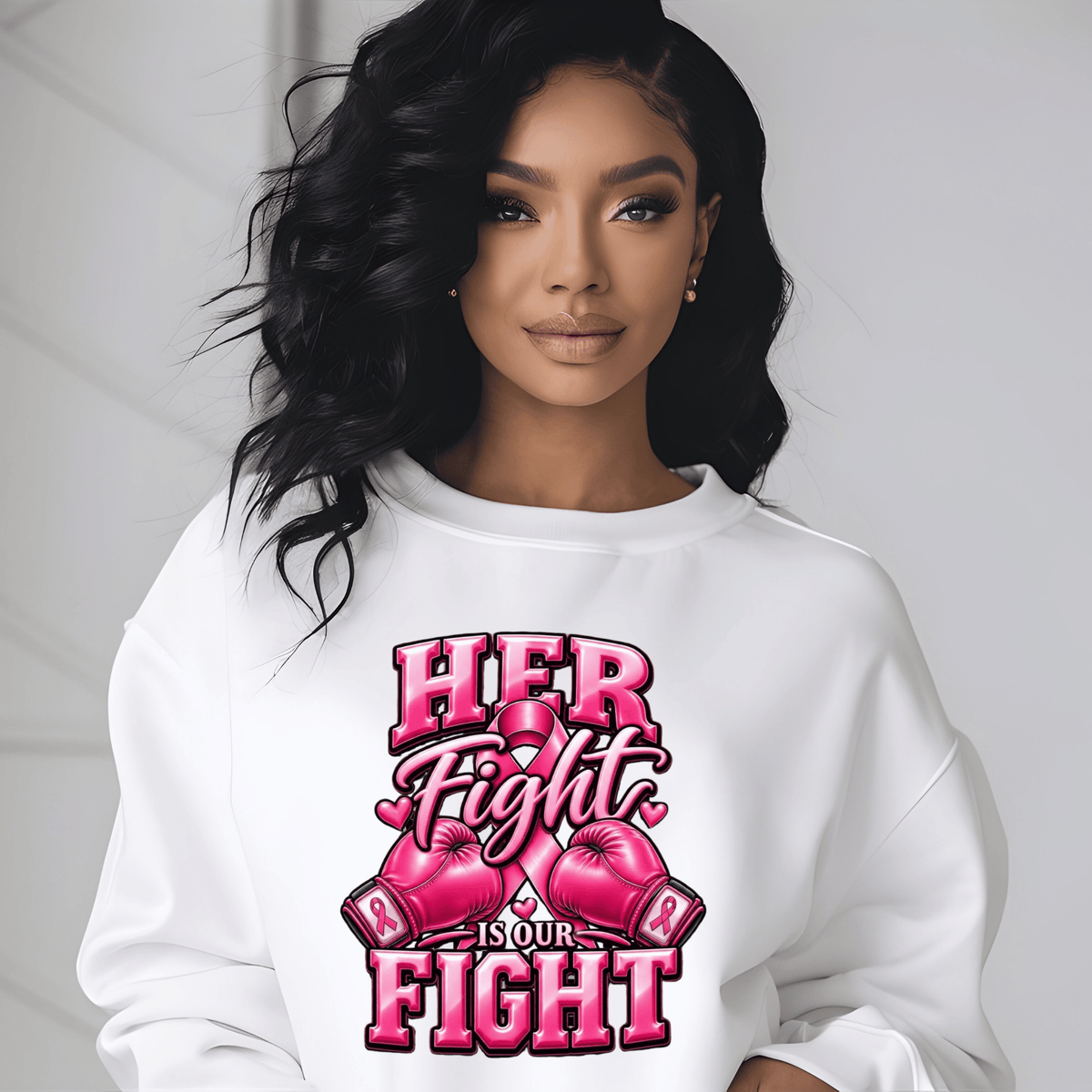 A woman wearing a white crewneck sweatshirt with a pink graphic that reads 'HER Fight IS OUR FIGHT' with boxing gloves and a pink ribbon, set against a light gray background.