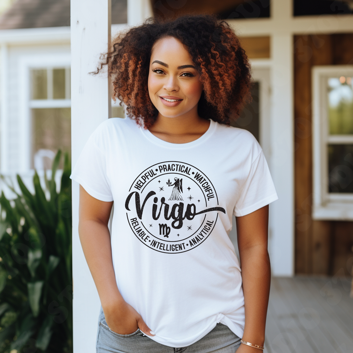 A woman with curly brown hair stands on a porch wearing a white graphic T-shirt with a black circular design that reads 'Virgo' and lists adjectives around it. The background shows a home exterior with white columns, wood siding, and green plants.
